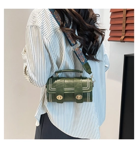 Close-up of retro green Boston bag featuring gold twist lock and printed wide strap