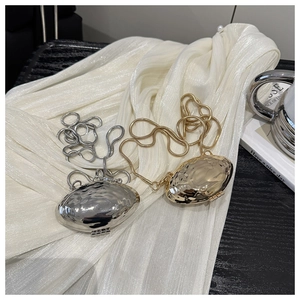 Close-up of metallic shell evening bags with water ripple texture in gold and silver