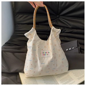 Vue détaillée du sac en toile avec motifs d'animaux mignons et anses tissées orange