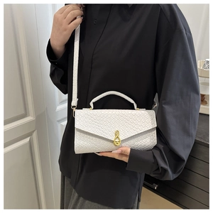 Detail of white woven texture handbag with golden teardrop lock on a black shirt background
