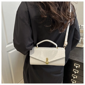 Detailed view of white crocodile pattern square handbag with gold musical note lock buckle