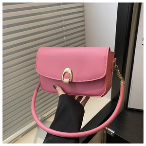 Detailed close-up of pink leather handbag featuring a golden horseshoe metallic lock