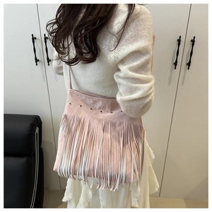 Pink bohemian tassel shoulder bag detail shown on model with fringe design