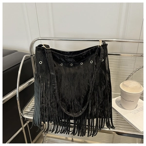 Détail du sac en velours noir à franges avec œillets argentés sur support métallique