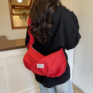 Red nylon crescent dumpling crossbody bag with adjustable strap for casual daily use