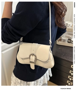 Detailed view of cream leather half-moon bag with silver metal buckle and soft texture