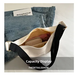 Detail view of white crescent bag interior showing large capacity with accessories