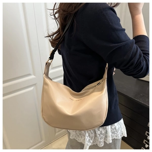 Detail of beige hobo shoulder bag with black adjustable strap and gold hardware