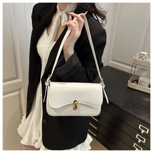 Detailed close-up of white ivory baguette bag with elegant golden twist lock clasp
