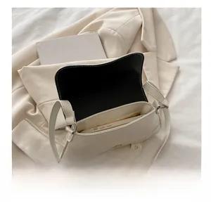 Interior view of off-white shoulder bag showing capacity for a smartphone and essentials