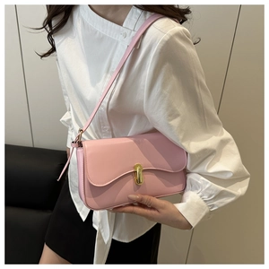 Detailed view of pink leather shoulder bag with gold twist lock on a female model