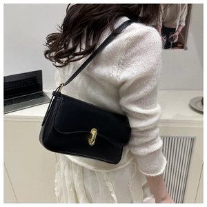 Close-up of elegant black leather shoulder bag with premium gold metal twist lock buckle