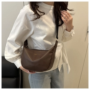 Détail d'un sac hobo demi-lune marron foncé avec bandoulière en nylon réglable