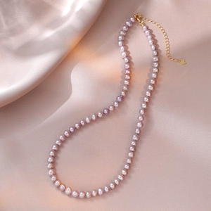 Close-up of 6-7mm lavender freshwater pearl necklace with gold S925 silver clasp on silk