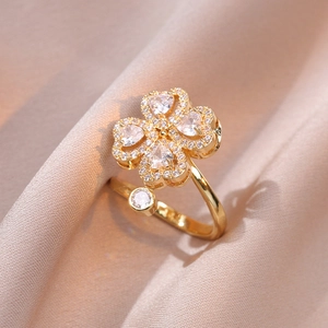 Dettaglio di un anello regolabile in oro con trifoglio e zirconi a cuore su seta
