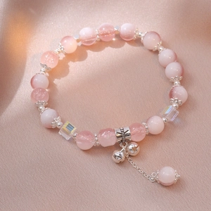 Pink cherry agate and moonstone beaded bracelet with silver bells on soft fabric