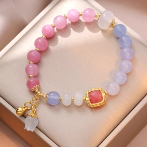 Pink and purple beaded flower bell bracelet on a luxury golden satin jewelry box