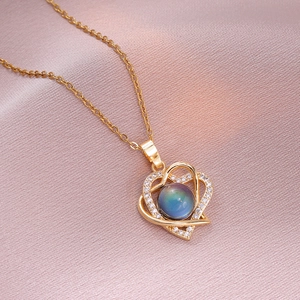 Collier double cœur doré avec cristaux brillants et pierre centrale changeant de couleur