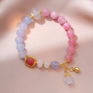 Elegant floral beaded bracelet with pink beads, gold bell, and square gem pendant