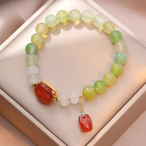 Beaded bracelet with apple green agate and red pendant in a minimalist jewelry box