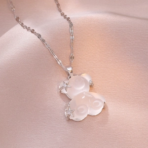 Elegant bear pendant necklace with star zircon details on pink satin background