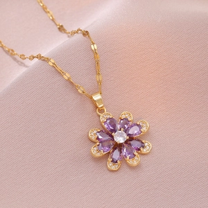 Elegant gold necklace with a purple zircon flower pendant on soft satin fabric