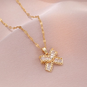 Collier nœud doré élégant avec pendentif en zircone sur tissu satiné rose