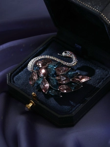 Vue détaillée de la broche cygne avec cristaux roses et bleus dans un coffret cadeau