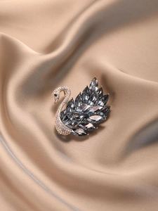 Détail de la broche cygne sertie de cristaux gris et de strass colorés sur satin soyeux