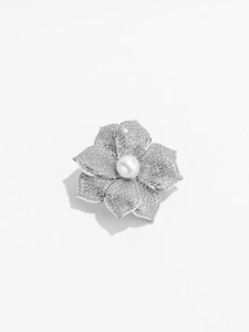 Détail d'une broche fleur avec perle d'eau douce et cristaux sur pétales argentés