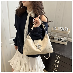 Detail of champagne leather hobo bag with large 3D star metal buckle and rivet accents