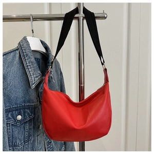 Close-up of red hobo bag showing soft leather texture and golden metal hardware