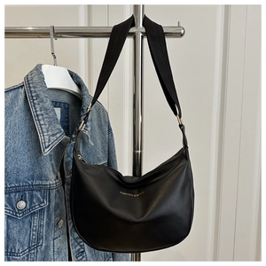 Detail of black semi-circle Hobo bag with gold text and wide woven shoulder strap