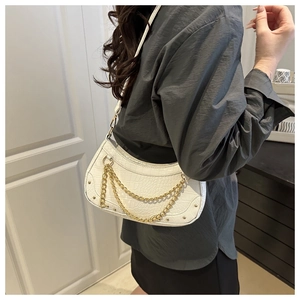 Detailed view of a white crocodile embossed crescent bag with gold chain and rivets