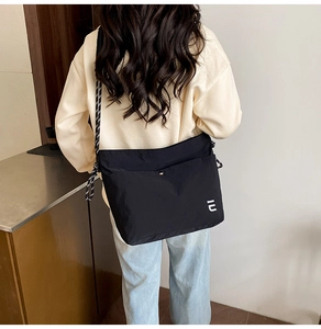 Detail of nylon tote bag showing white IU logo and adjustable woven rope shoulder strap