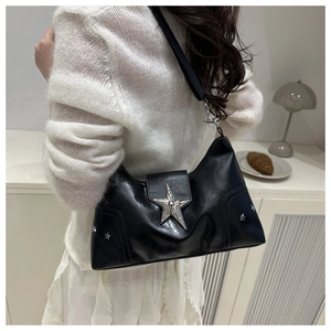 Détail du sac à bandoulière noir avec boucle étoile argentée et rivets étoiles