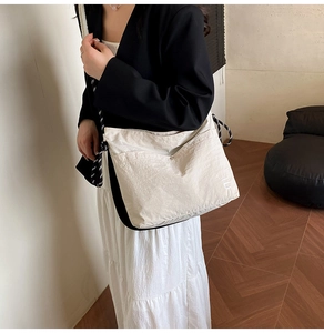 Detail of white nylon crossbody bag with braided rope strap and button pocket
