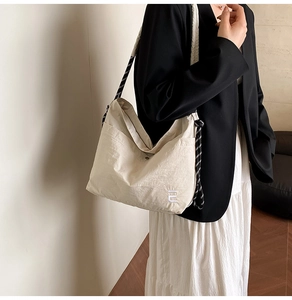 Détail du sac fourre-tout en nylon blanc cassé avec bandoulière en corde noire et blanche