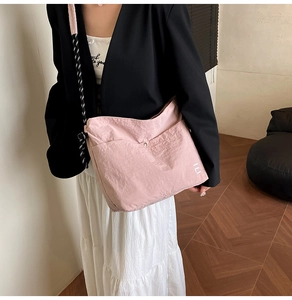 Sac cabas rose en nylon froissé avec bandoulière tressée et boucle élégante