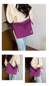 Détail du sac fourre-tout en nylon violet avec logo IU et bandoulière tissée rayée