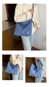 Détail du sac fourre-tout en nylon bleu avec logo IU et bandoulière en corde tressée