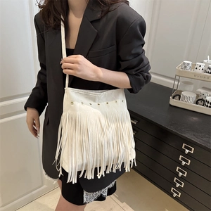 Sac bandoulière beige chic avec de longues franges et des œillets sur un modèle
