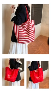 Macro detail of large red and white striped canvas tote bag showing stitching and texture