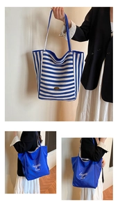 Detail view of large stripe canvas tote and blue minimalist shopper with printed logo