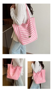 Detail of large canvas tote bag showing striped and solid pink designs for casual use
