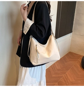 Detail view of the beige hobo bag with side zipper and long shoulder strap for women