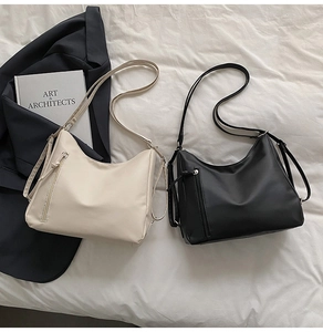 Close-up of beige and black matte PU leather hobo bags with vertical zipper pocket detail