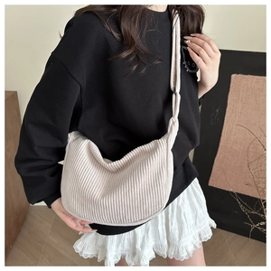 Detail of cream corduroy hobo bag showing the wide strap and soft textured fabric