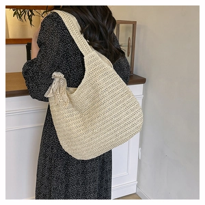 Detail of hand-woven straw tote bag with lace bow decoration and crochet texture