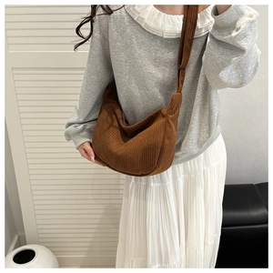 Detailed texture of brown corduroy crescent bag with adjustable wide shoulder strap